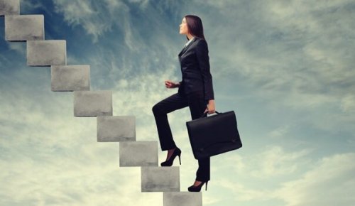 Kvinde med ambition går op ad trapper 