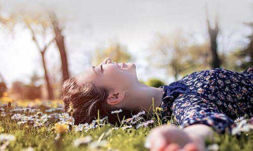 Kvinde på græs forstår, at lykke kommer i små handlinger