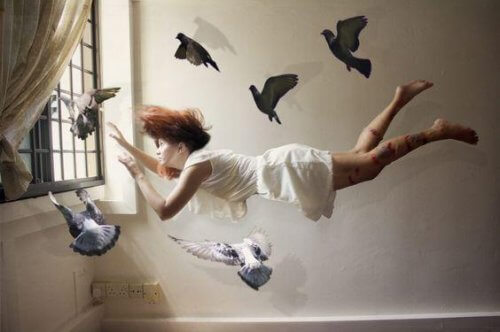 Kvinde flyver i værelse med fugle omkring sig
