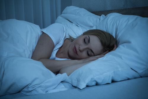 kvinde sover i sin seng og nyder en god nats søvn