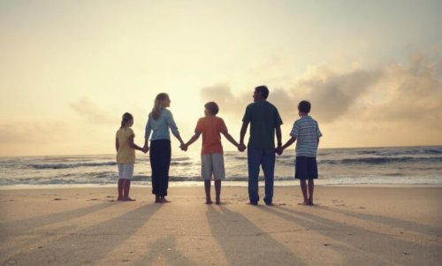 Familie hånd i hånd på strand