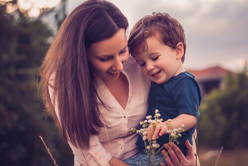 Kvinde med søn kigger på en blomst