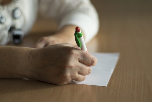 Person skriver på papir