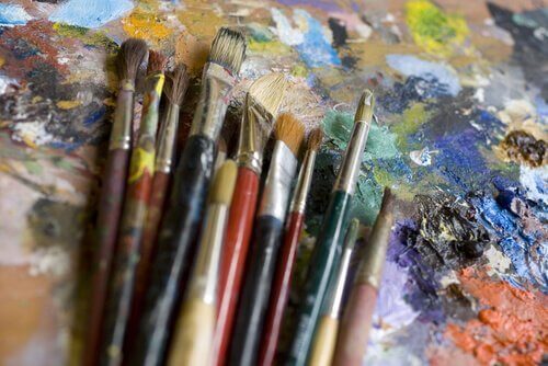 Pensler og maling symboliserer at overvinde traumer med kunst