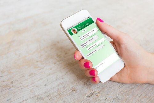 Kvinde med telefon i hånd er afhængig af WhatsApp
