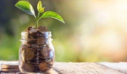 Spirende krukke med mønter illustrerer, at vi kan bevare energien ved at undgå gæld