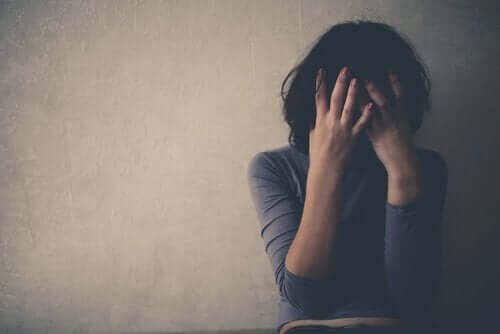 En kvinde tager sig til ansigtet som følge af at være offer for Lima syndrom