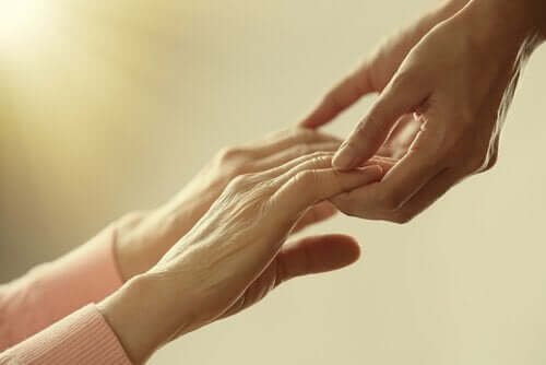 To par hænder, der rækker ud mod hinanden, illustrerer ældrelivet på et plejehjem