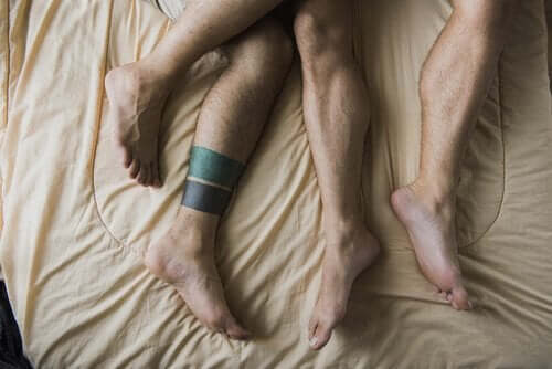 To mænds ben i seng illustrerer kammeratsex