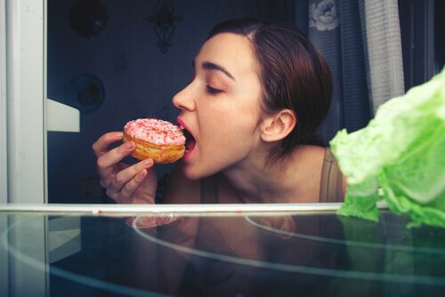 kvinde sætter tænderne i en kage