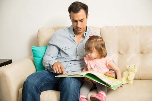 Far læser bog med datter i sofa som symbol på epigenetik