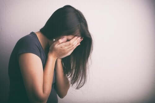 kvinde med ansigtet begravet i sine hænder