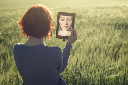 Kvinde på vejen til selvindsigt ser sig selv i spejl på mark