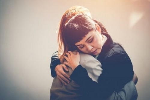 To kvinder giver hinanden et kram