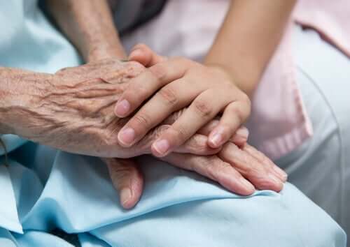 Barn holder om ældre persons hånd