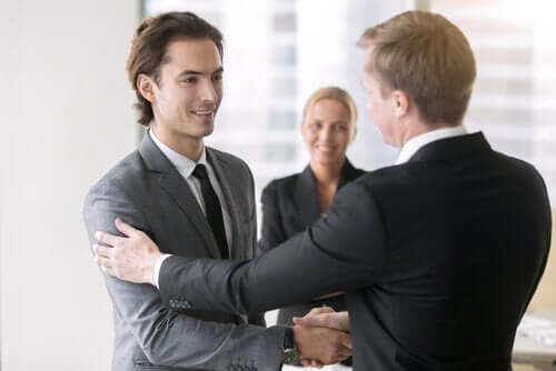Forretningsmænd giver hinanden hånden som illustration af at være glad på andres vegne