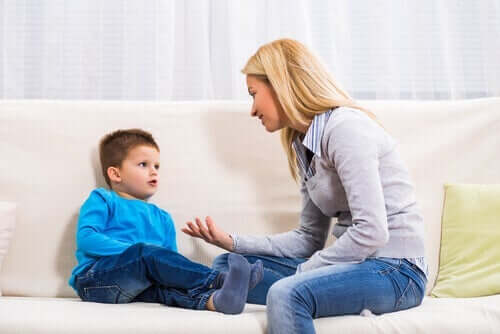 Kvinde snakker med dreng i sofa