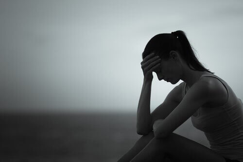 Kvinde sidder alene og er trist