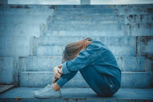 trist teenager hviler hoved på knæ