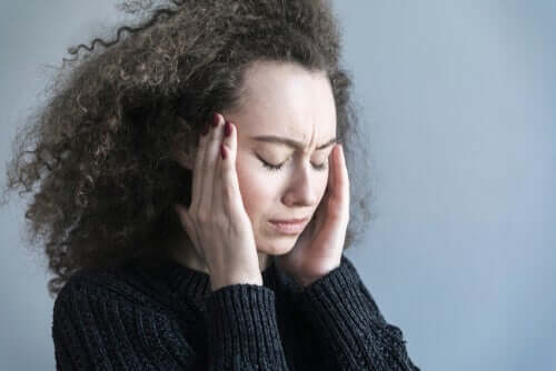 Kvinde, der tager sig til hoved, har brug for behandling af migræne