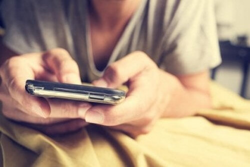 Mand sender beskeder fra sin mobiltelefon 