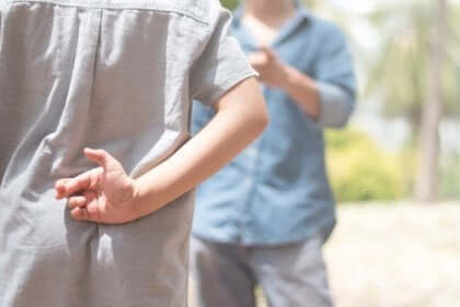 dreng, der krydser fingre bag ryggen