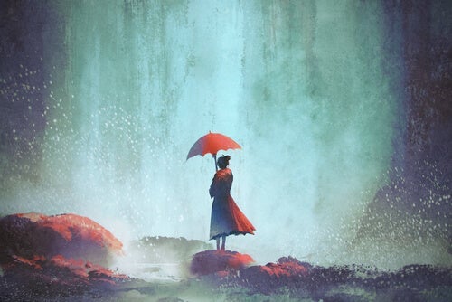 Kvinde med paraply ved vandfald arbejder på at tage afstand fra oplevelser