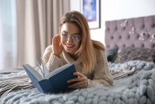 Kvinde læser bog i seng