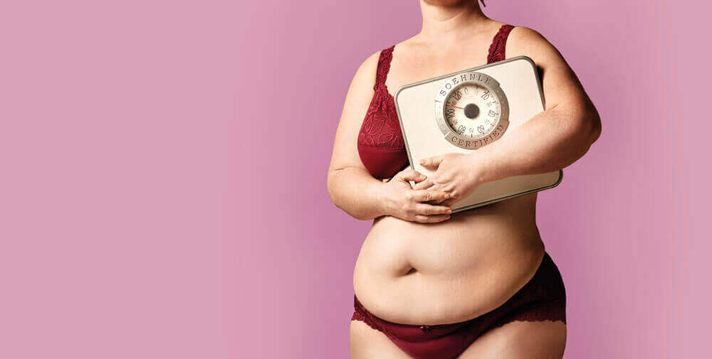Overvægtig kvinde med vægt symboliserer sammenhængen mellem overvægt og skyld