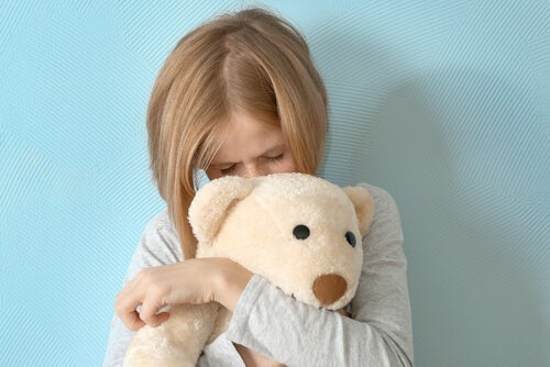 Pige, der krammer bamse, illustrerer humørforstyrrelser hos børn