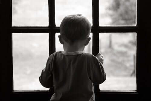 Lille dreng ser ud af vindue