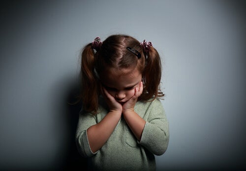 Trist pige tager sig til kinderne