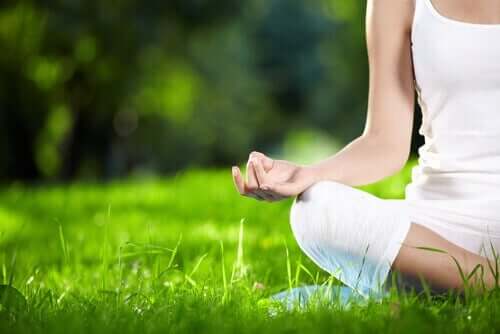 kvinde, der mediterer i græs