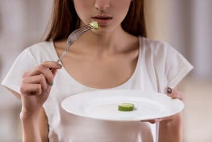 kvinde med en skive agurk på tallerken