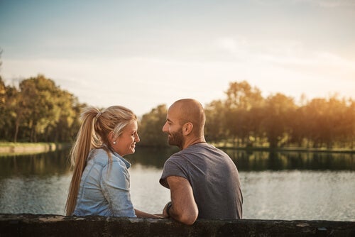 Mand og kvinde sidder ved sø og illustrerer, hvordan man kan skabe en forbindelse med andre