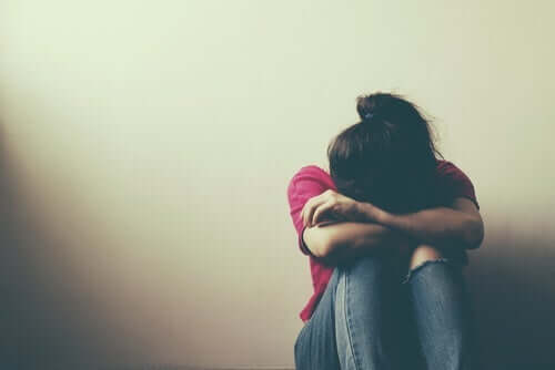 En pige græder med hovedet i armene som følge af risikabel adfærd hos teenagere