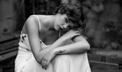 Trist kvinde hviler hoved på arm