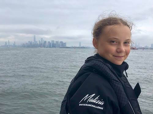 Greta Thunberg smiler foran hav