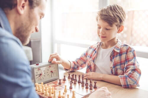 dreng spiller skak med voksen mand