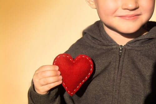 Dreng, der holder hjerte af filt, illustrerer, at man kan lære børn om taknemmelighed