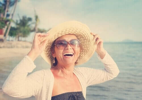 Smilende kvinde ved strand kan måle sin glæde med den subjektive glædesskala