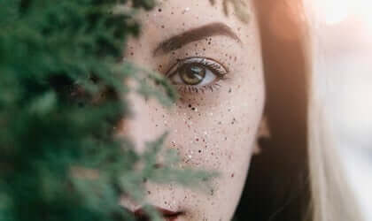 Kvinde ser ud bag træ