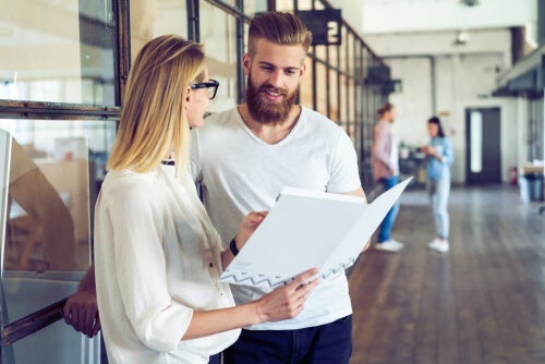 Kvinde viser mand mappe som eksempel på en god kollega
