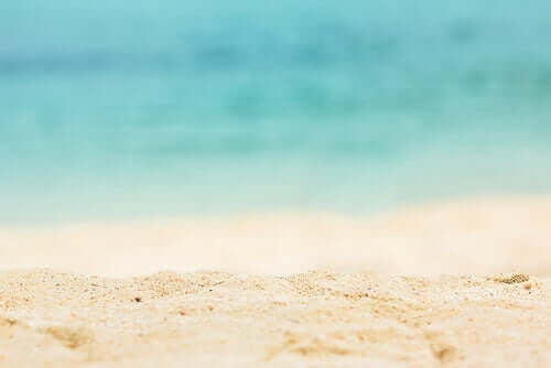 En strand med hvidt sand og blåt vand