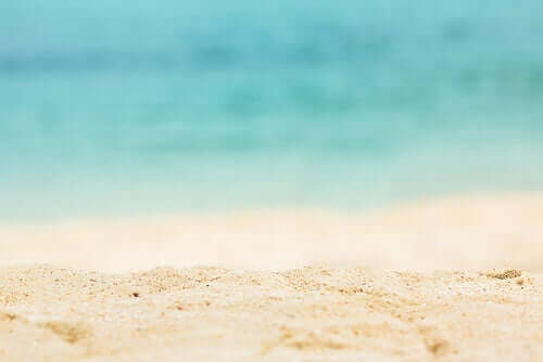 En strand med hvidt sand og blåt vand