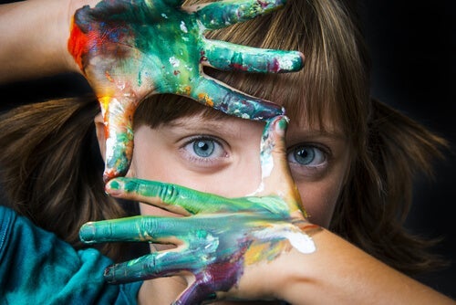 barn med maling på hænderne