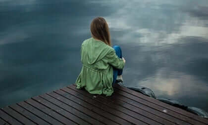 kvinde sidder ved en badebro