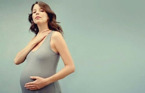 gravid kvinde, der holder på mave og hals