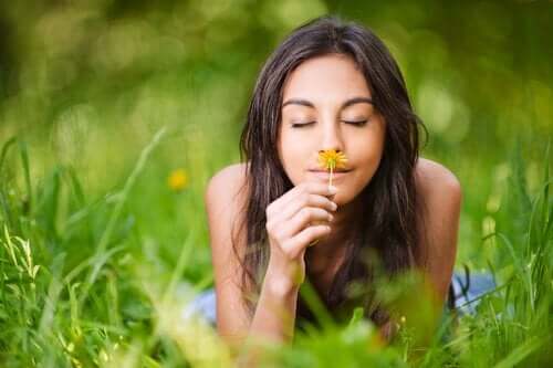 kvinde, der dufter til en blomst