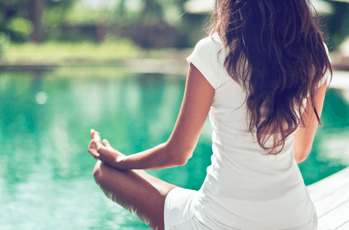 kvinde, der mediterer ved sø